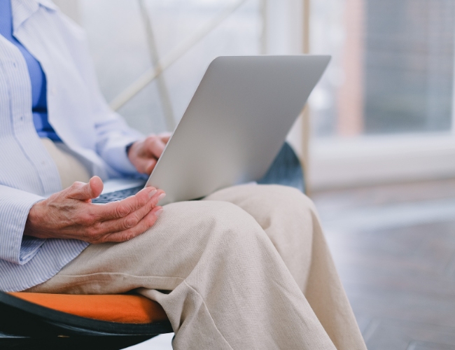 persoon op een stoel en een laptopcomputer op de schoot