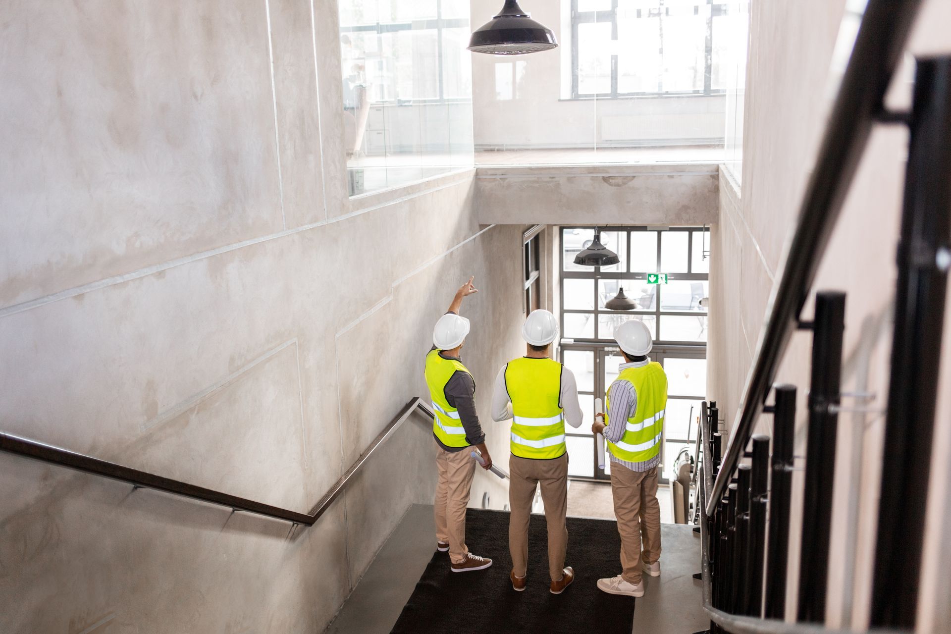 A group of construction workers are standing on top of a set of stairs.