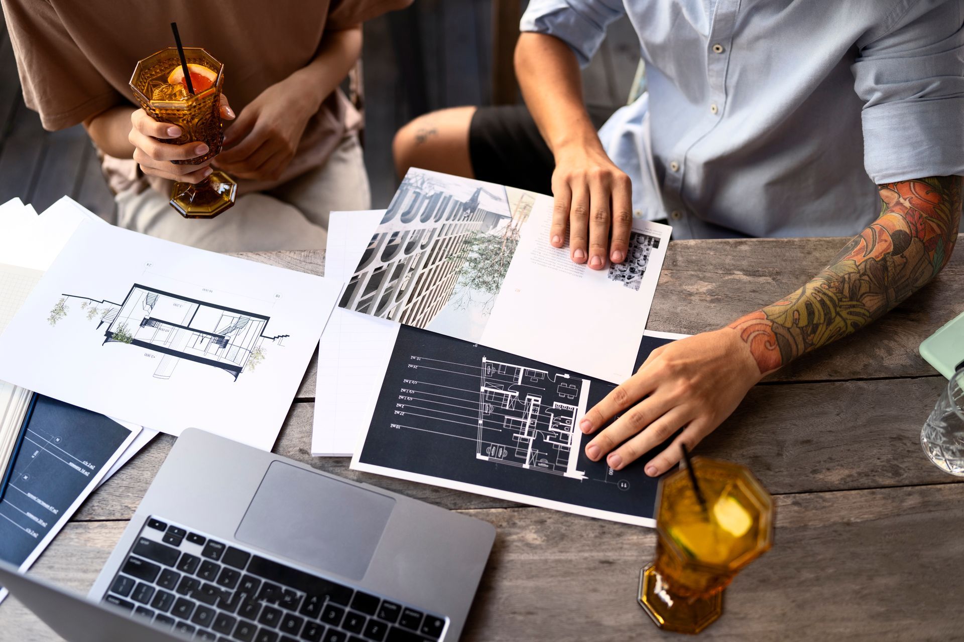 A man and a woman are sitting at a table with a laptop and papers.