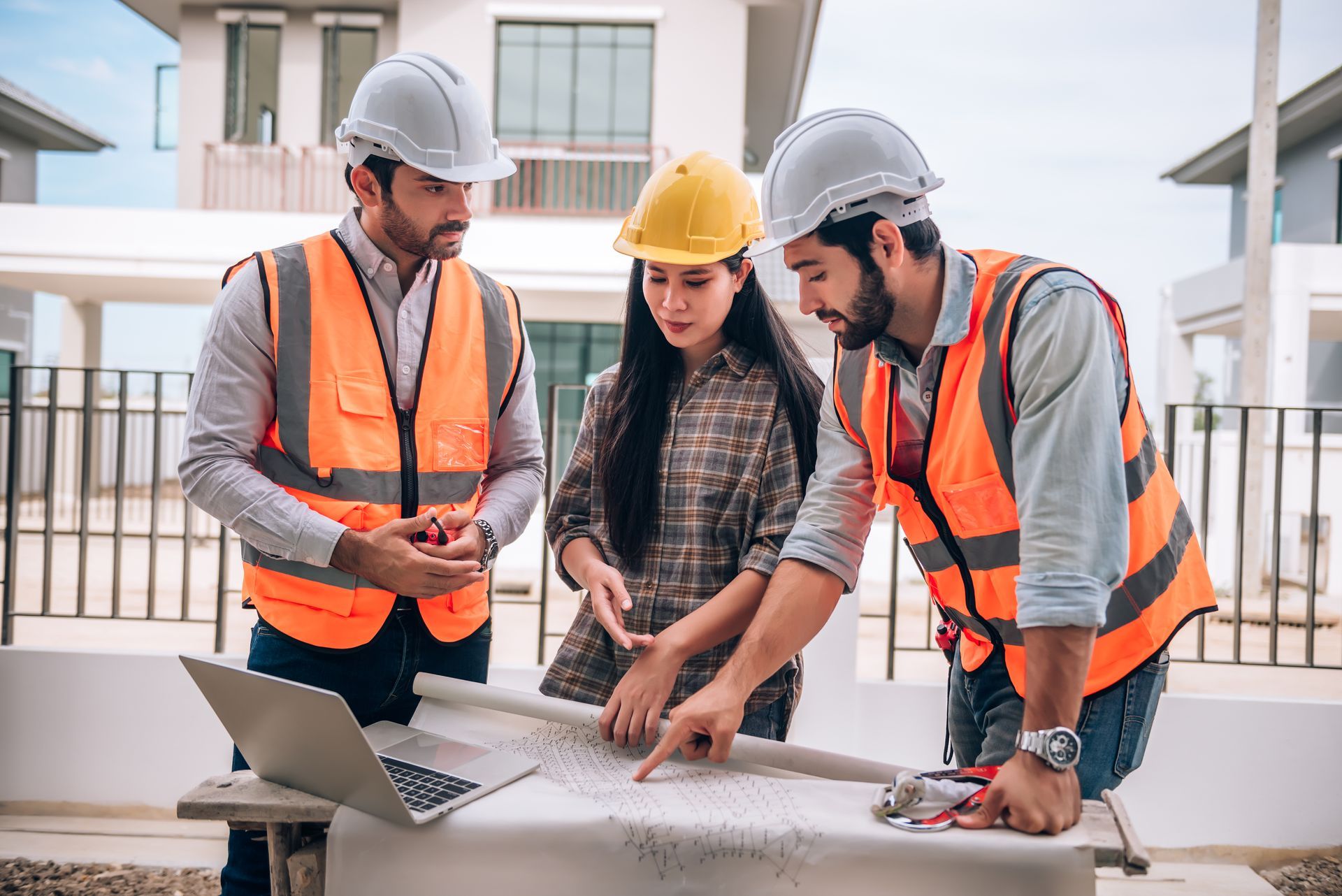 A group of construction workers are looking at a blueprint.