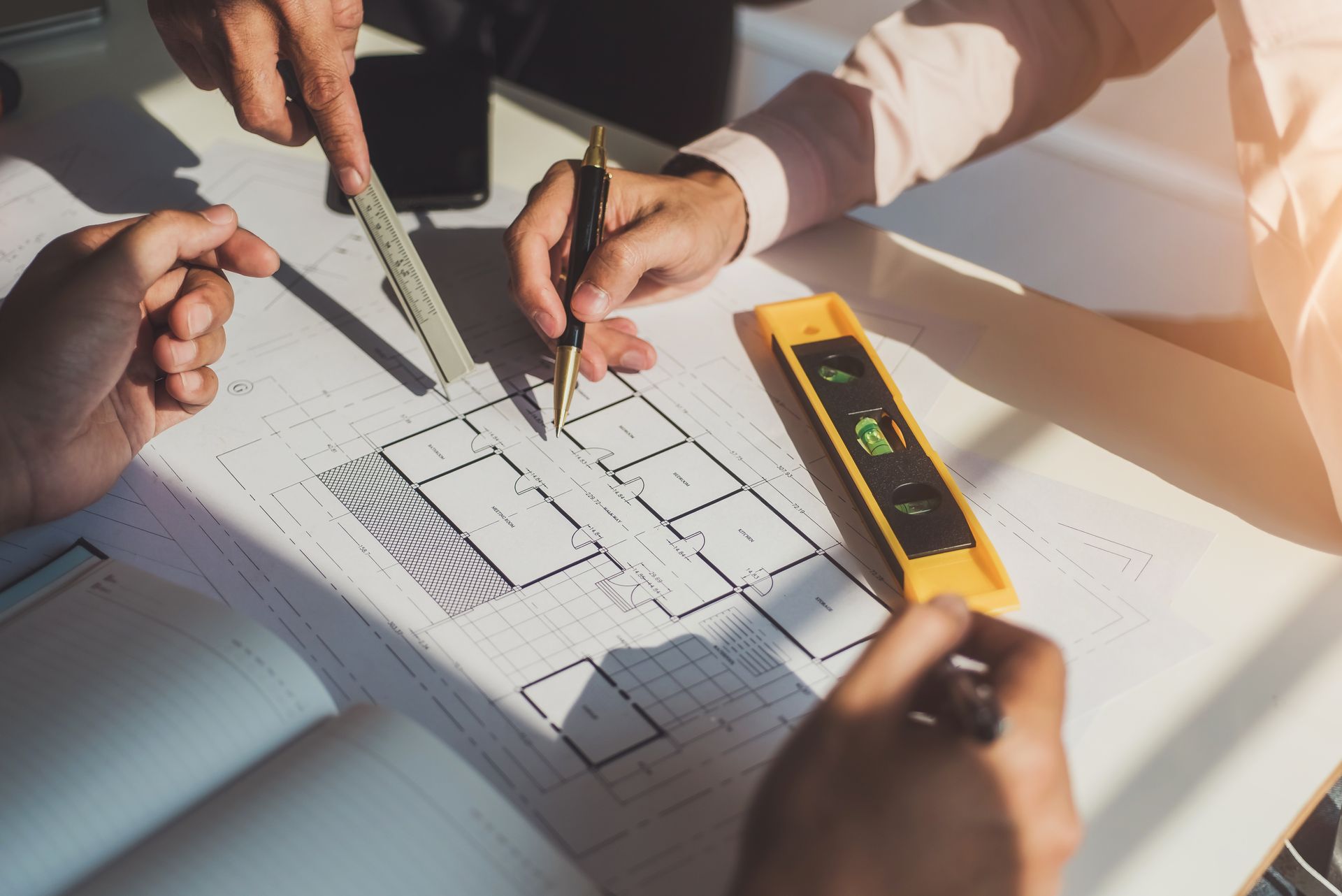 A group of people are working on a blueprint of a house.