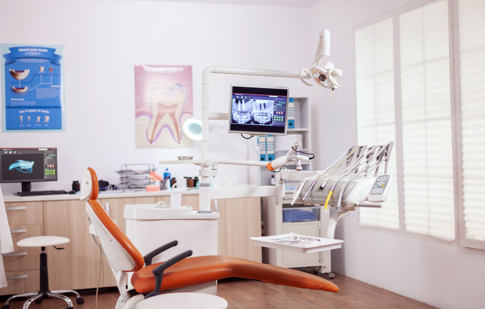 A dental office with a dental chair and a computer.