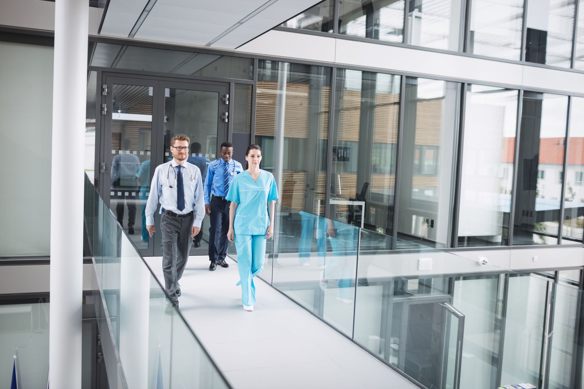 A group of people are walking down a hallway in a hospital.