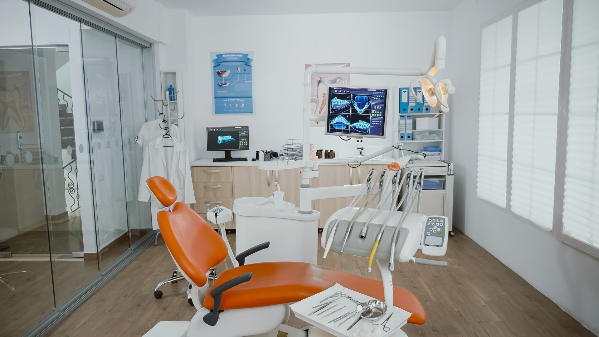 A dental office with a dental chair and a computer.