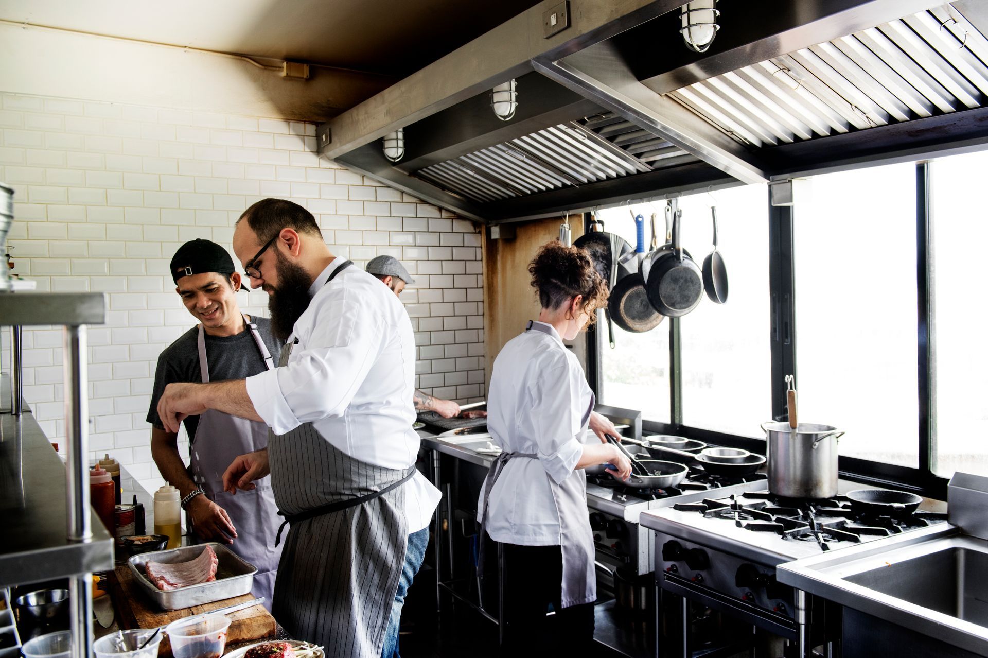 A group of chefs are preparing food in a commercial kitchen.