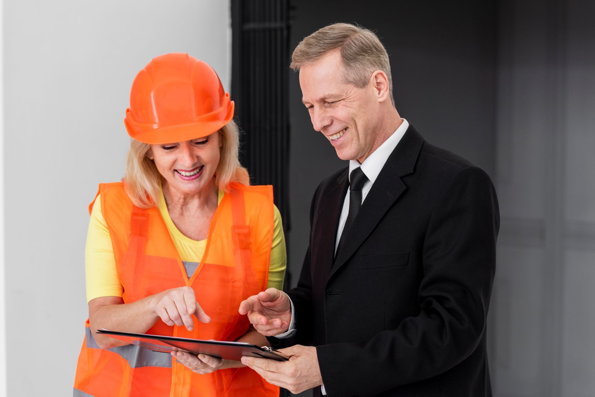 A man and a woman are looking at a clipboard.