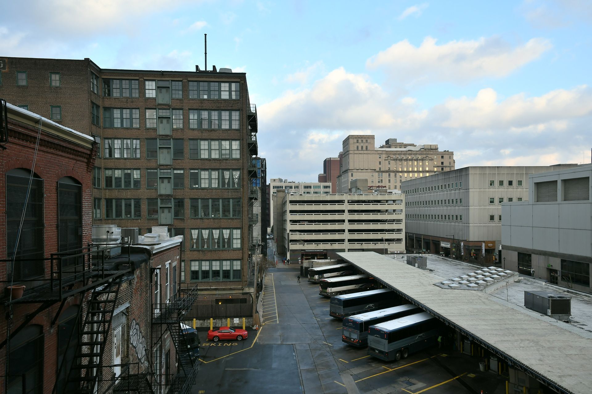 A row of buses are parked in front of a building
