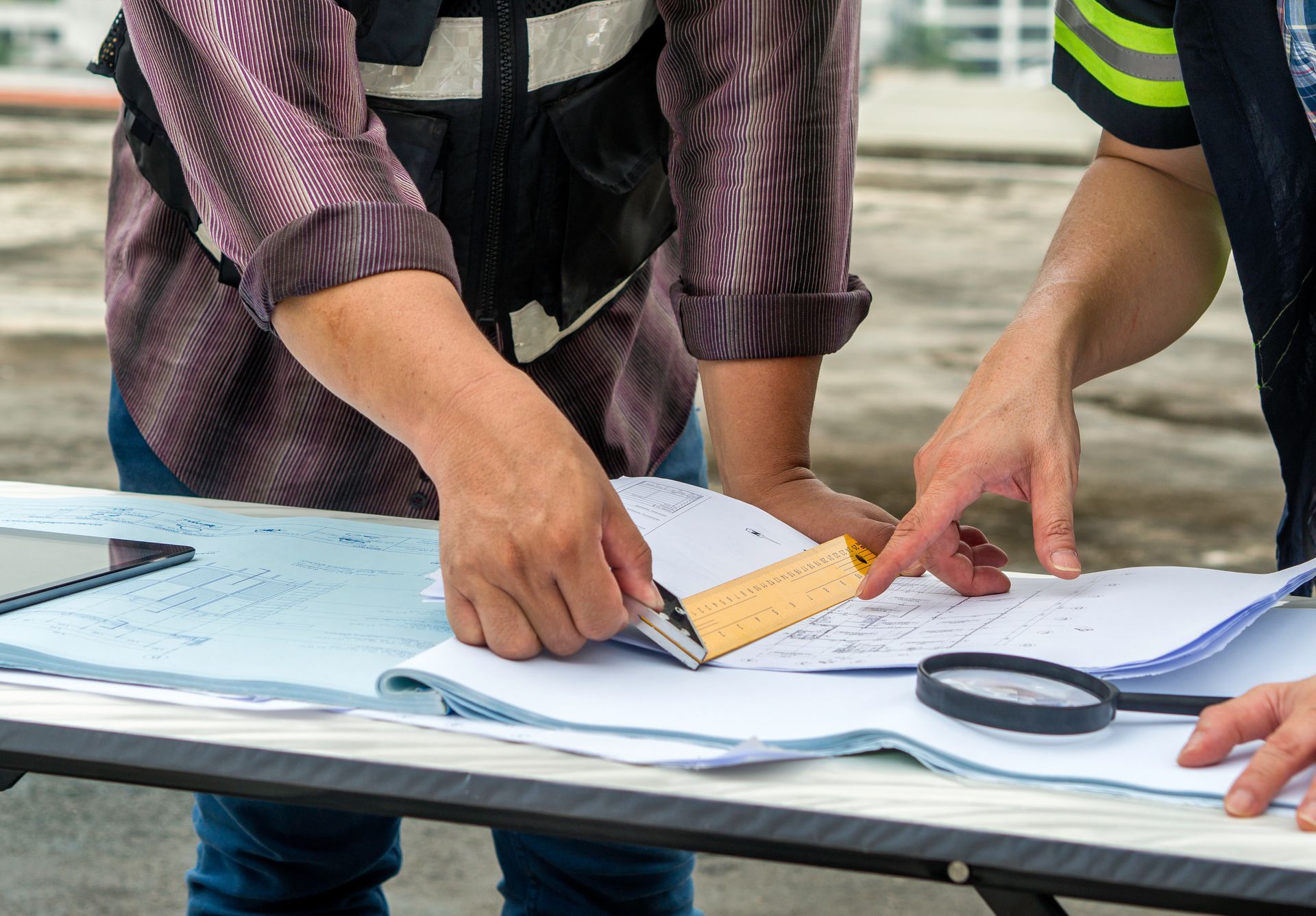 A man is measuring a piece of paper with a tape measure.