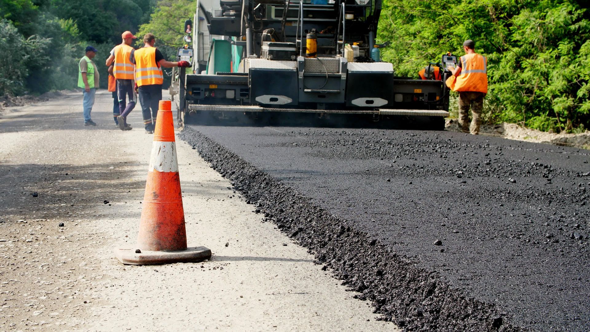 A group of construction workers are working on a road