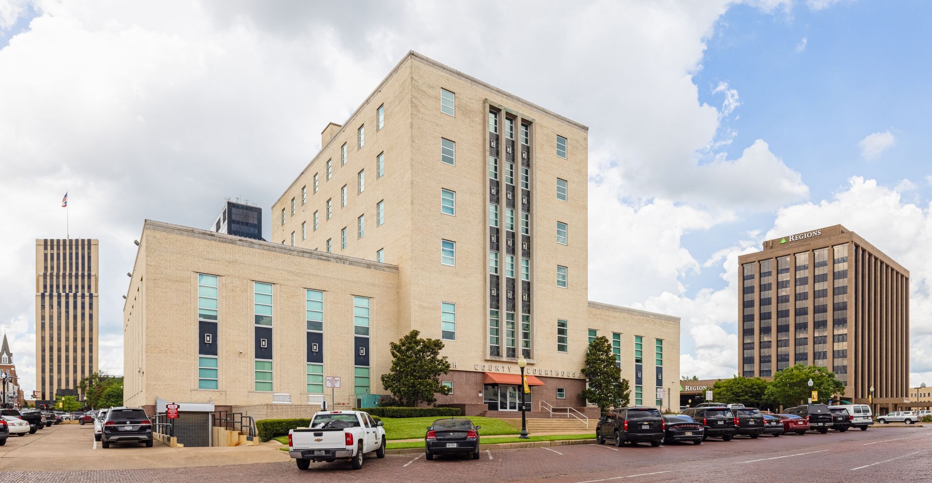 A large building with a lot of windows and cars parked in front of it.