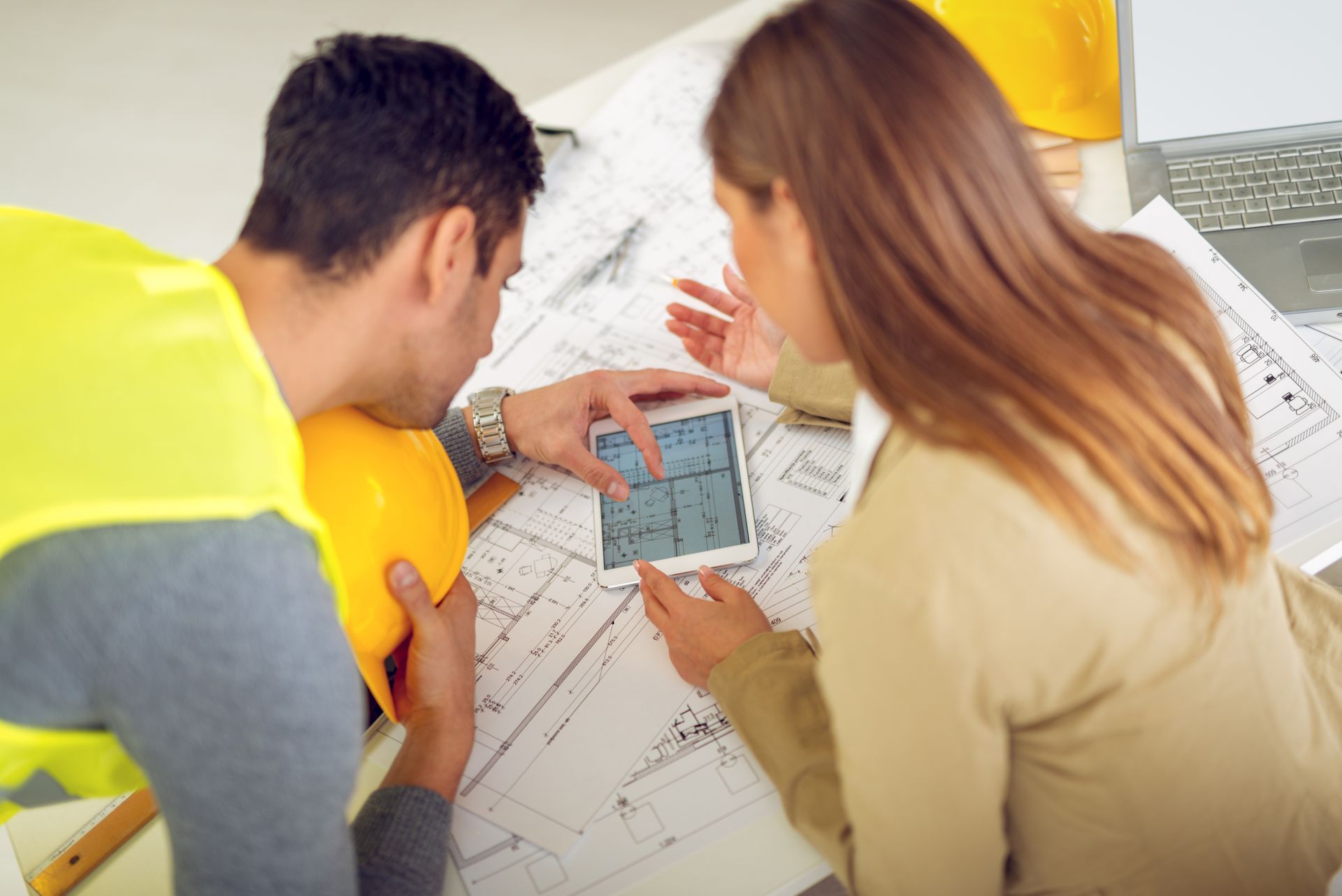 A group of people are working on a blueprint of a house.