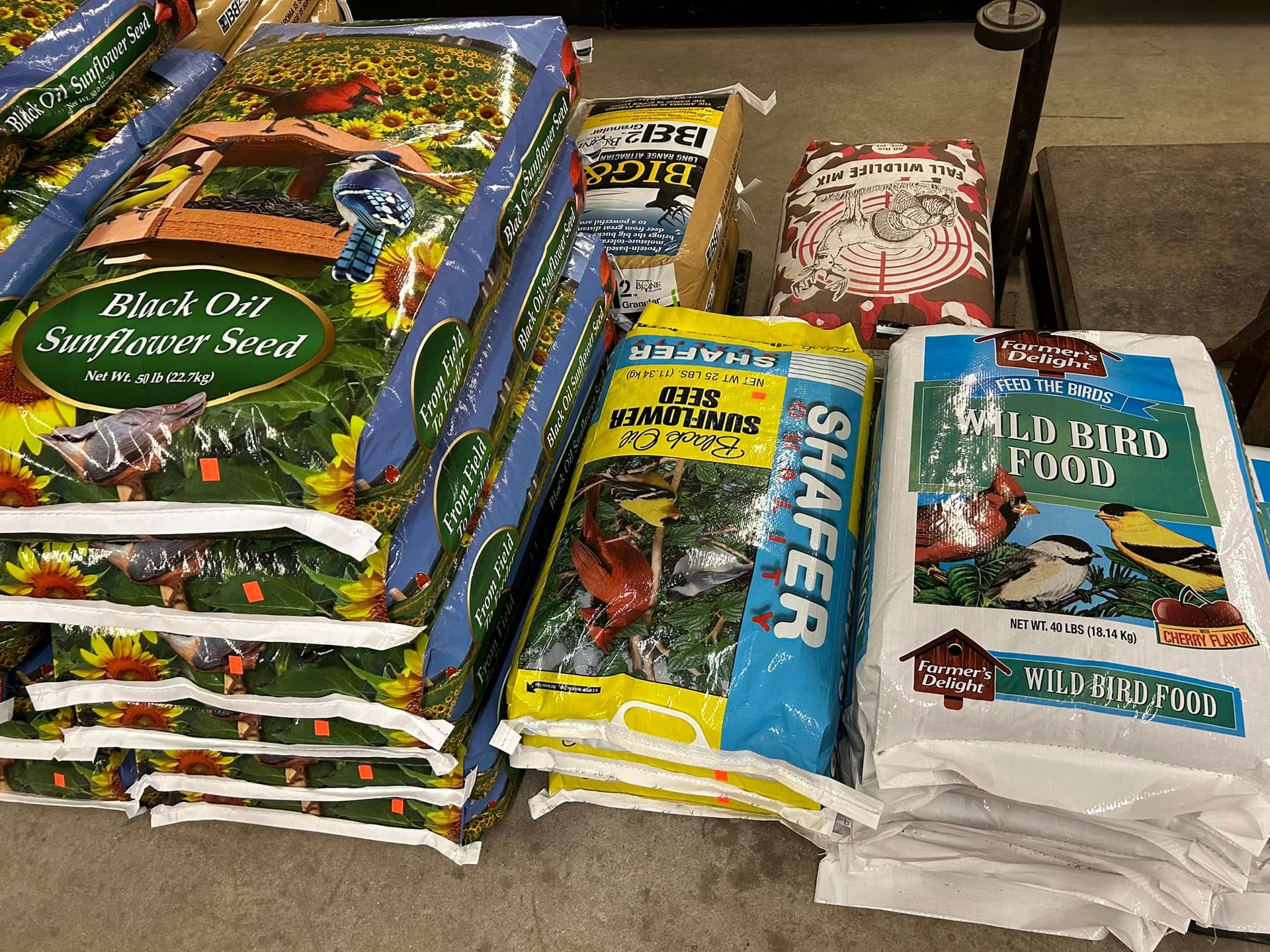 Bags of birdseed stacked on display; includes sunflower seed and wild bird food.