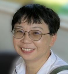 一頭黑色短髮、戴眼鏡的女子身穿白襯衫，面帶微笑。