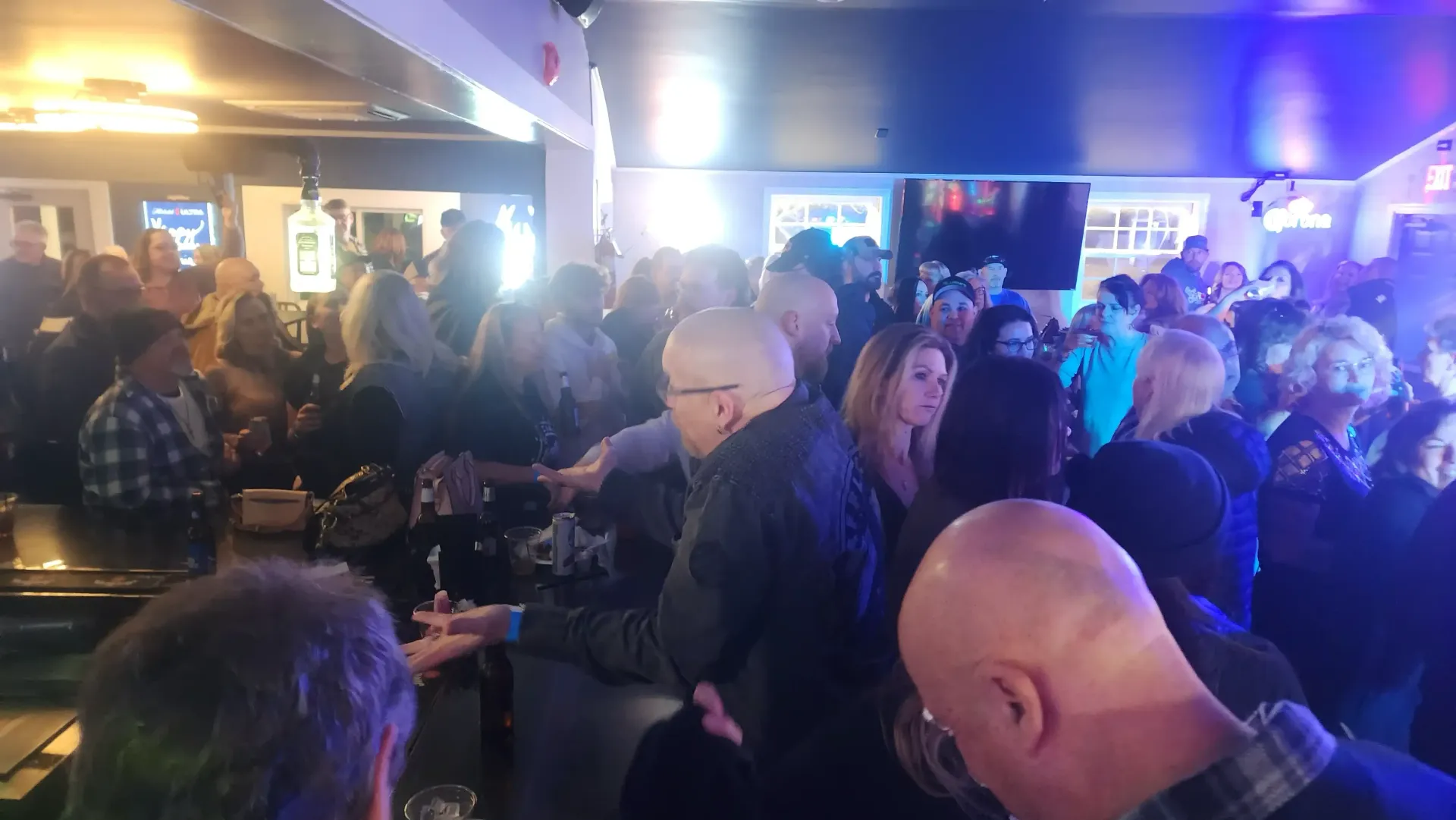 Group of regulars laughing at high-top tables