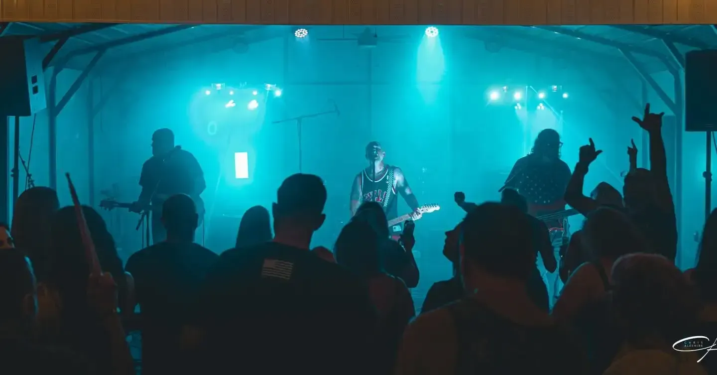 Live band performing on stage under colored lights