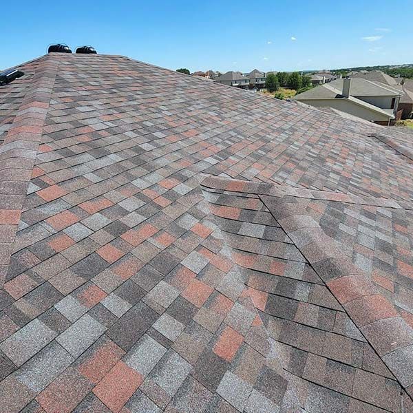 A roof with a lot of shingles on it and a blue sky in the background.