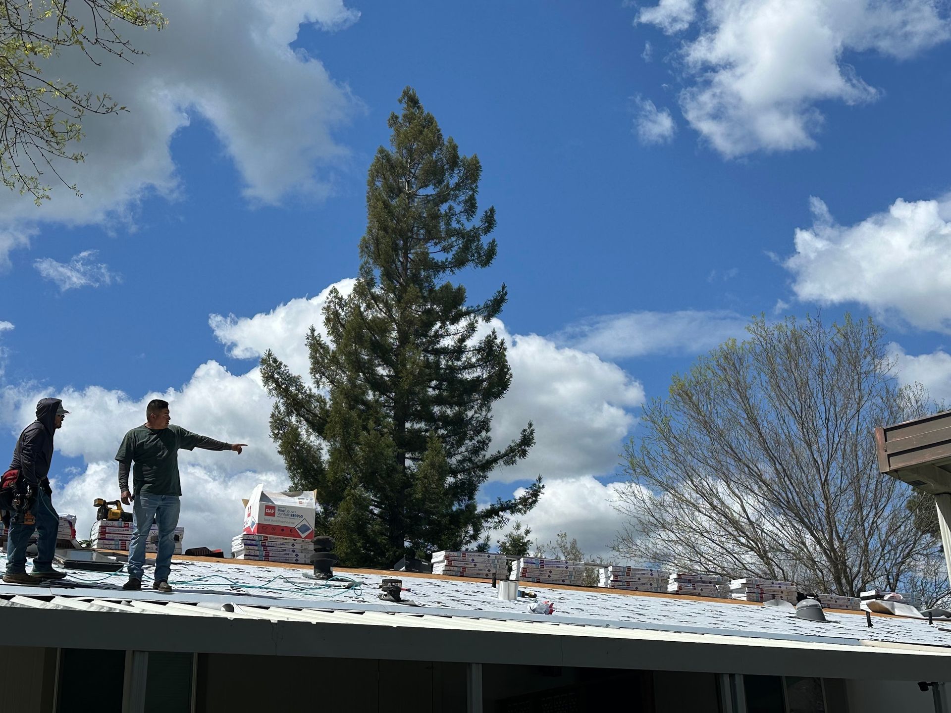 Two men are working on the roof of a house.