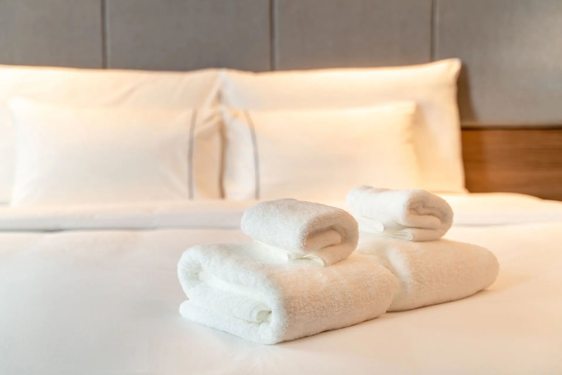 two towels are stacked on top of each other on a bed