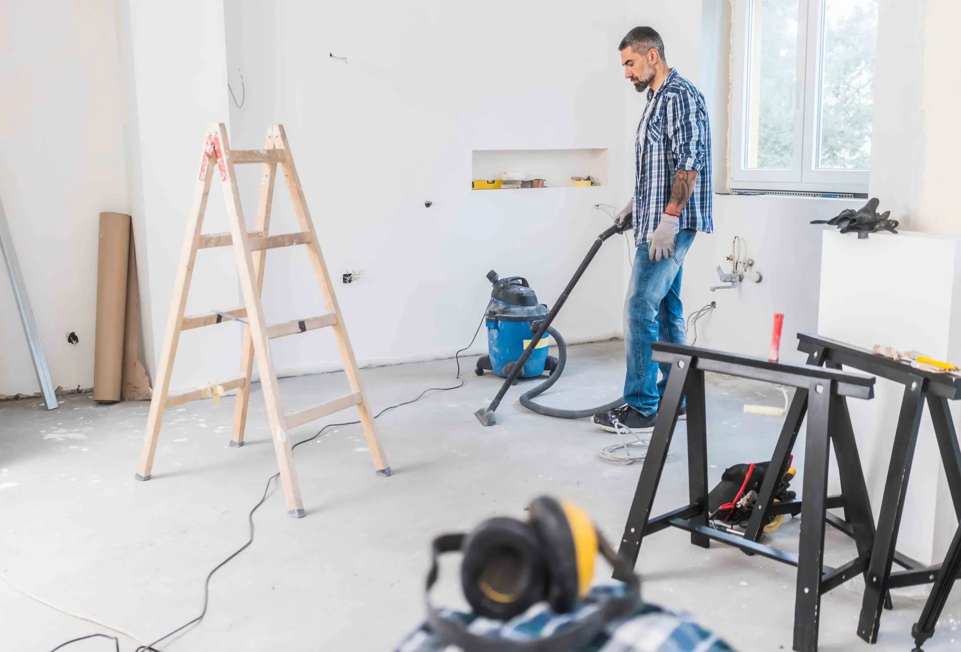 a man is using a vacuum cleaner in a room under construction