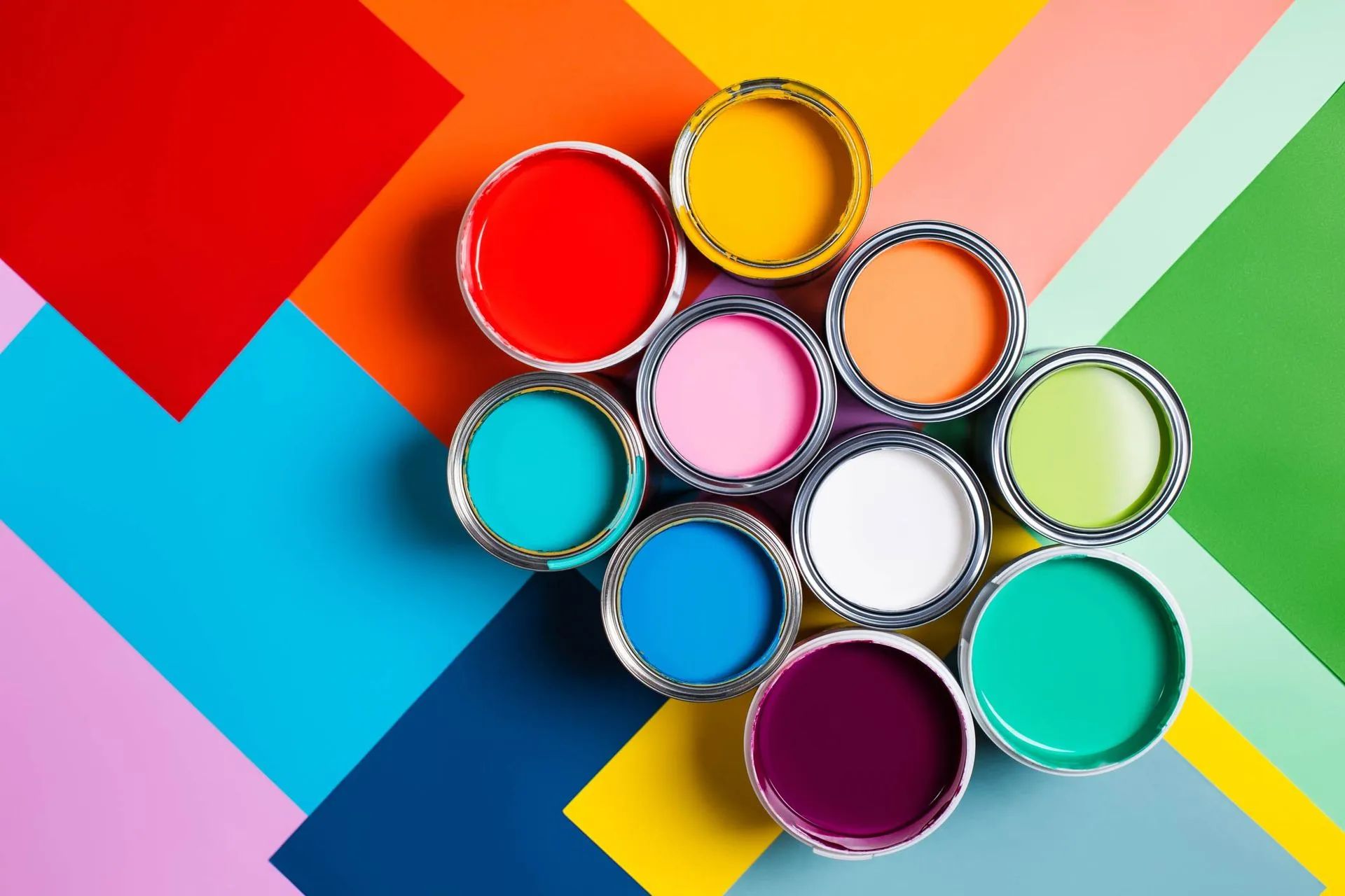 a bunch of cans of paint are stacked on top of each other on a colorful background