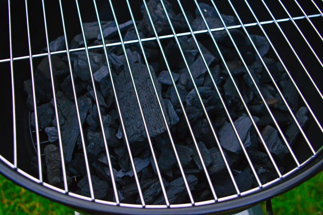 a close up of a grill with charcoal in it