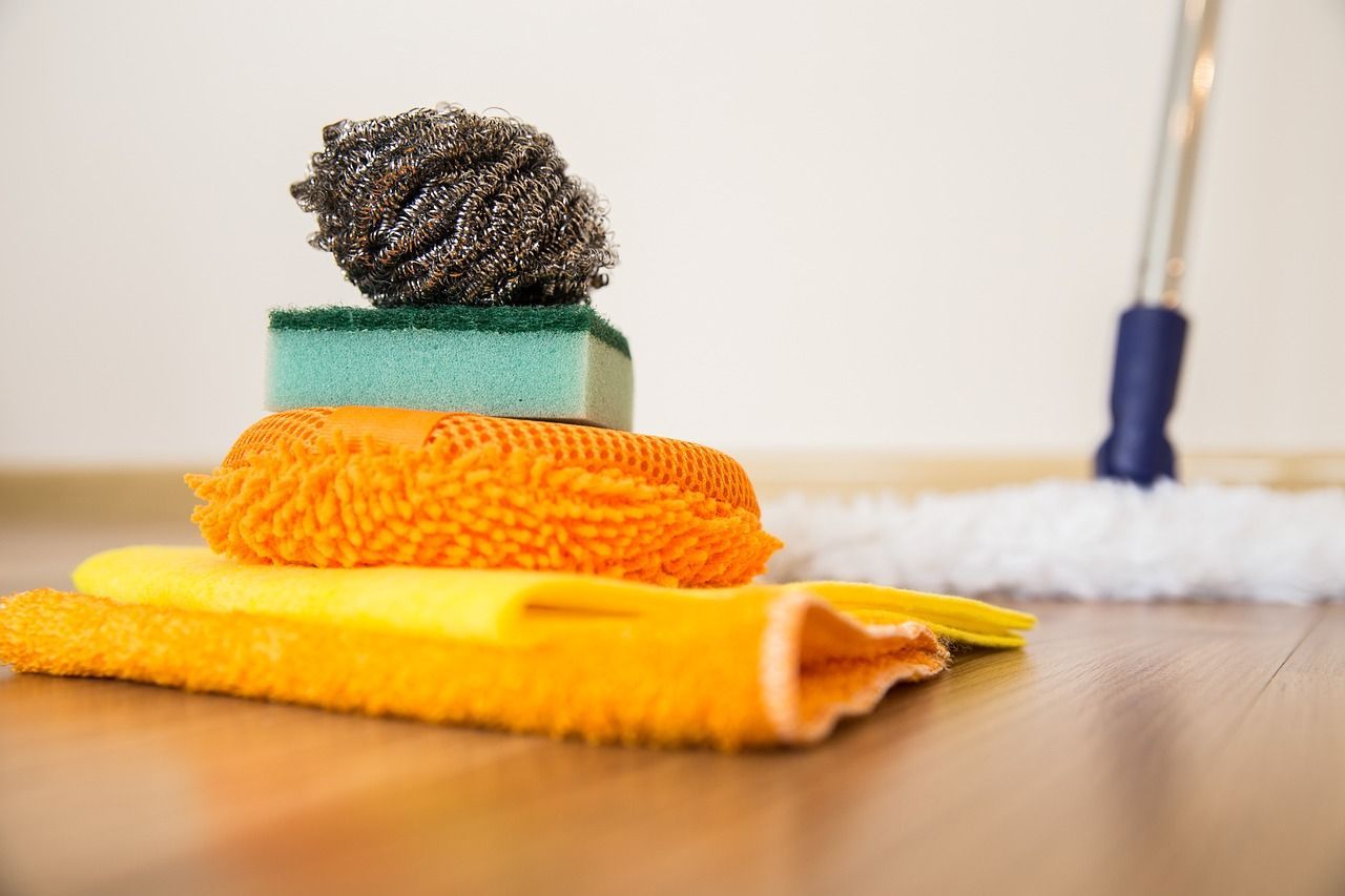 cleaning supplies are stacked on top of each other on the floor next to a mop 