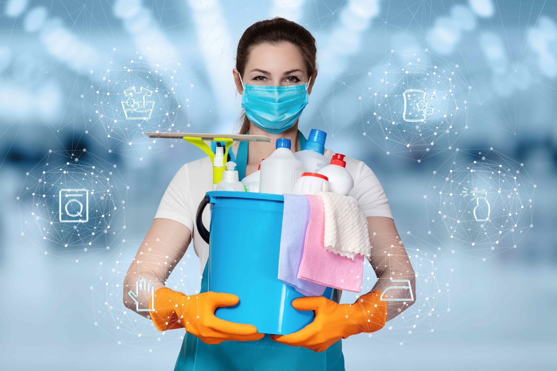 a woman wearing a mask and gloves is holding a bucket of cleaning supplies