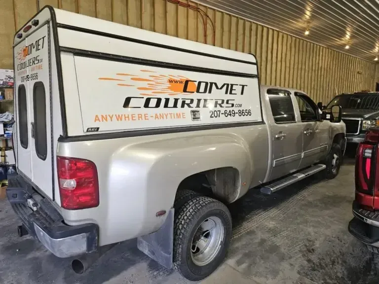 A comet courier truck is parked in a garage