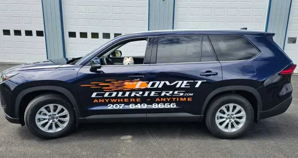 A blue suv with comet courier written on the side