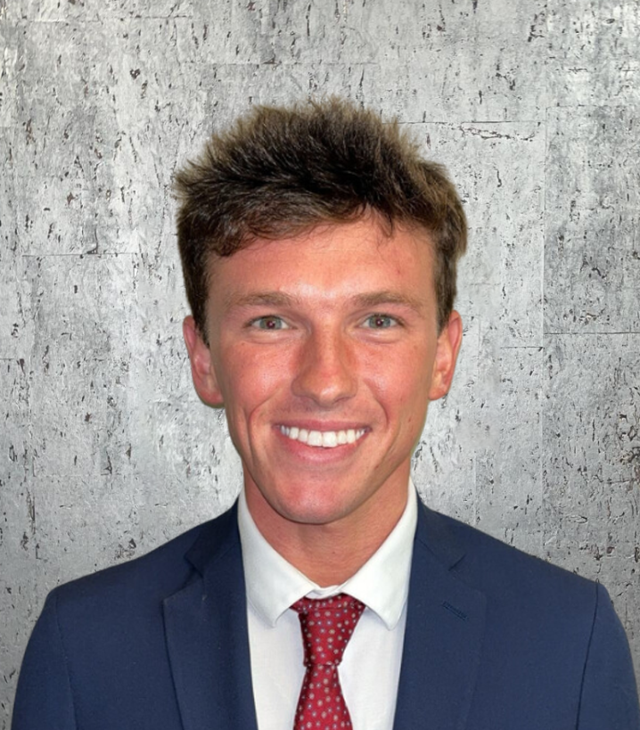 A man in a suit and tie is smiling for the camera