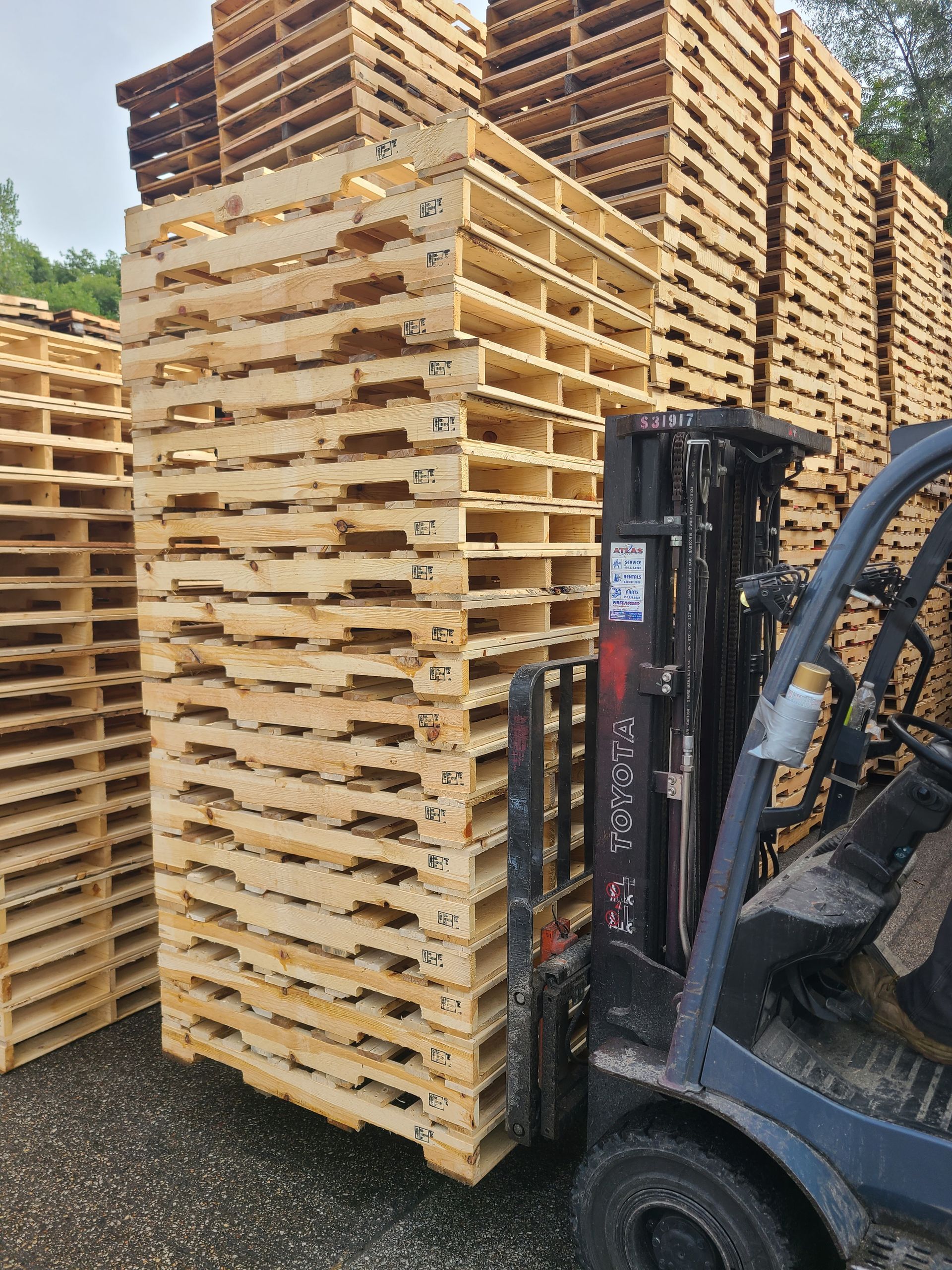 a forklift is moving a stack of wooden pallets
