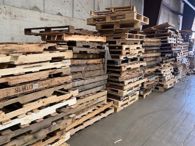 A warehouse filled with lots of wooden pallets