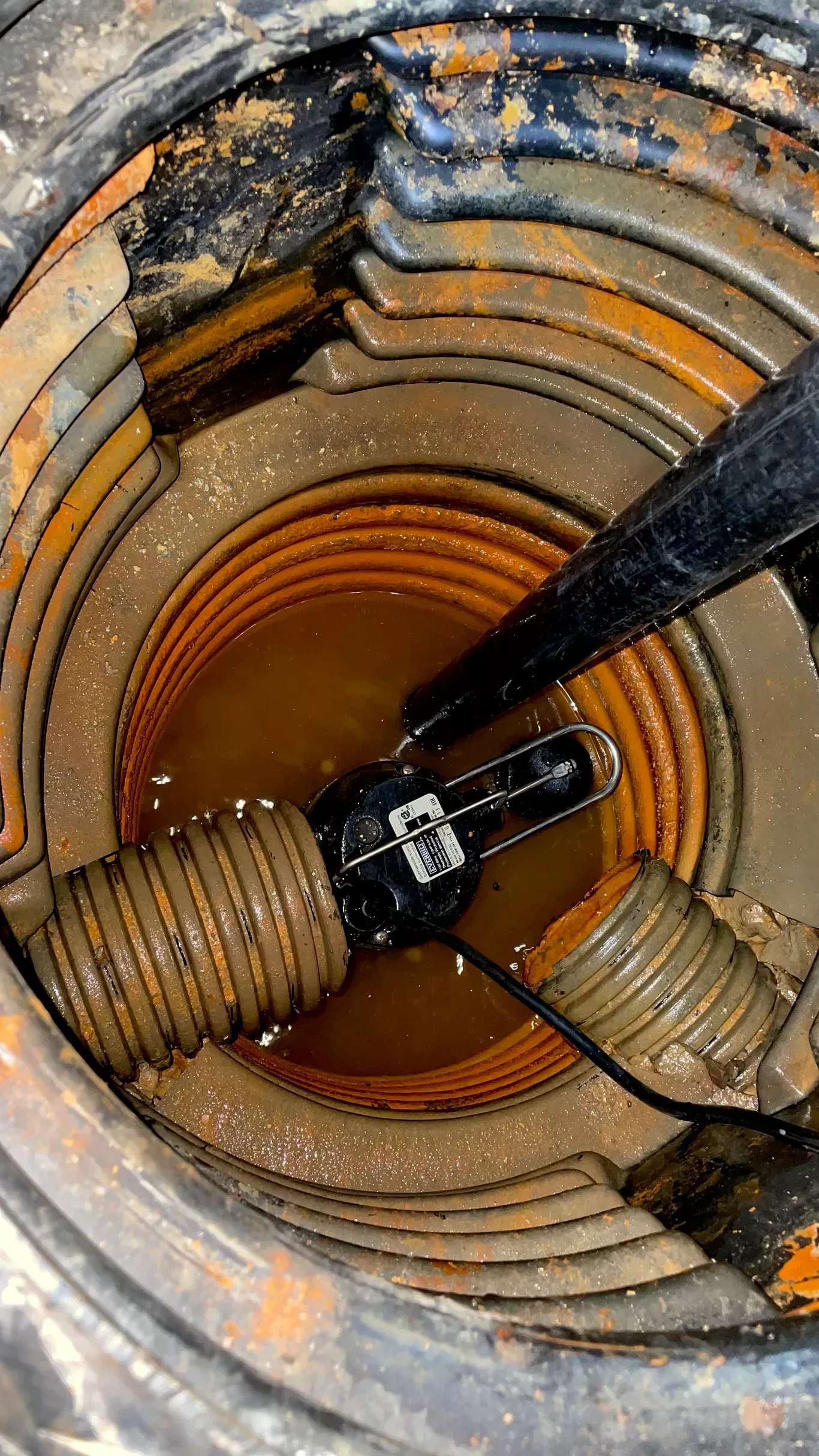 A close up of a drain with a vacuum hose in it.