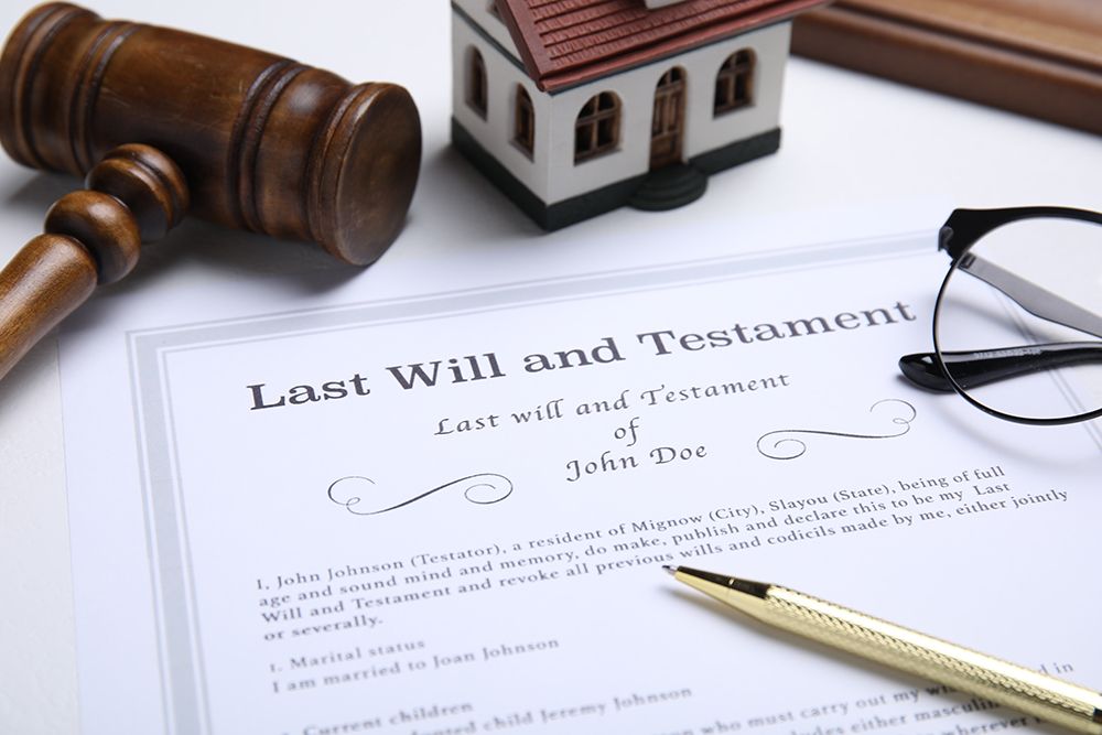 A wooden gavel is sitting on top of a last will and testament