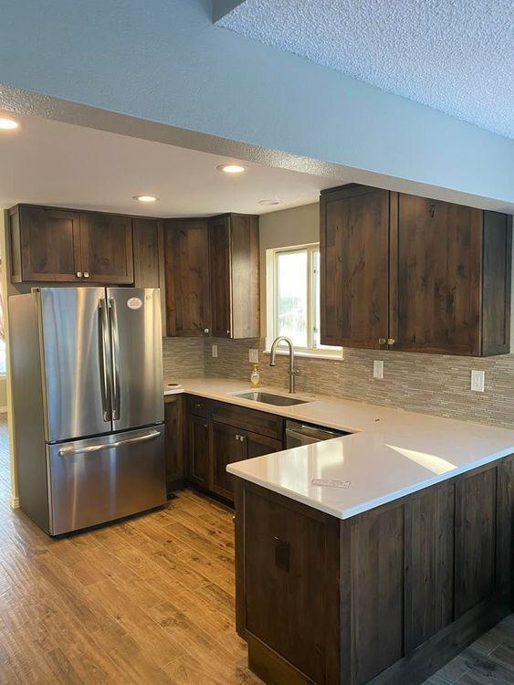 A kitchen with stainless steel appliances and wooden cabinets.