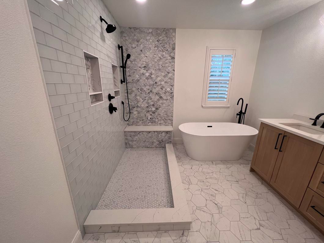 A bathroom with a bathtub and a walk in shower.