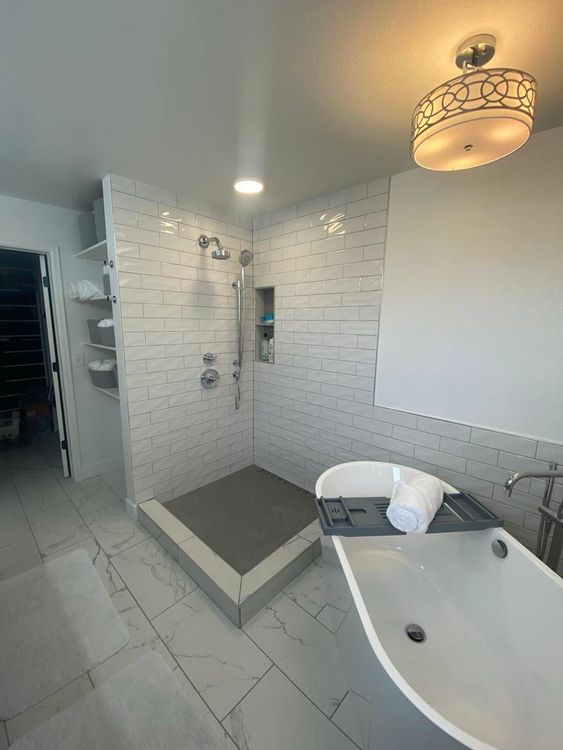 A bathroom with a tub , shower and sink.