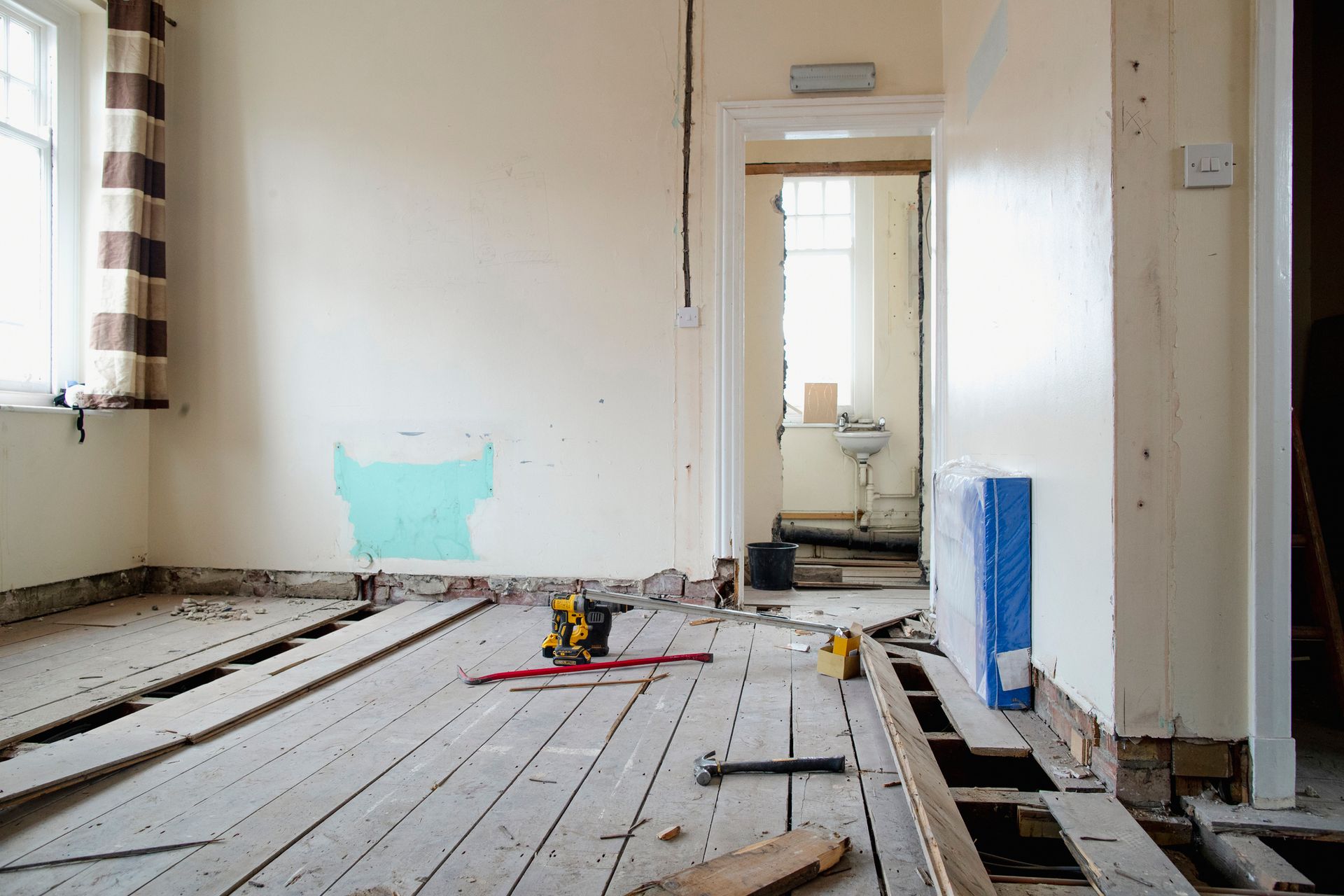 An empty room with a wooden floor and tools on it.