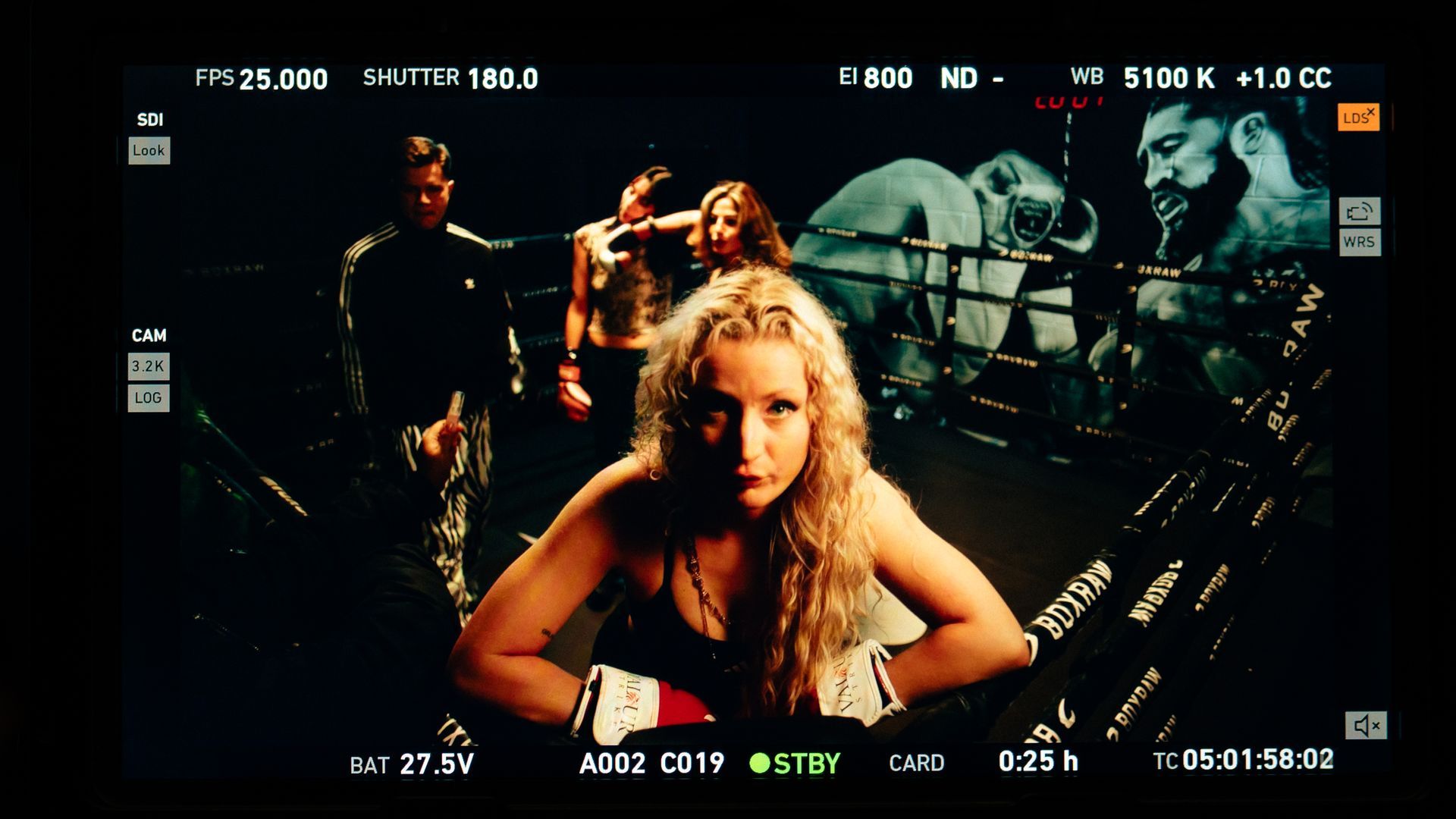 A woman in boxing gloves is being filmed on a camera