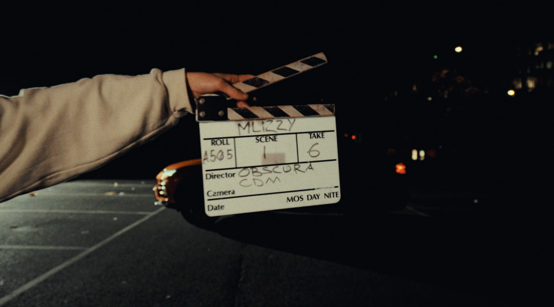 A person is holding a clapper board in their hand.