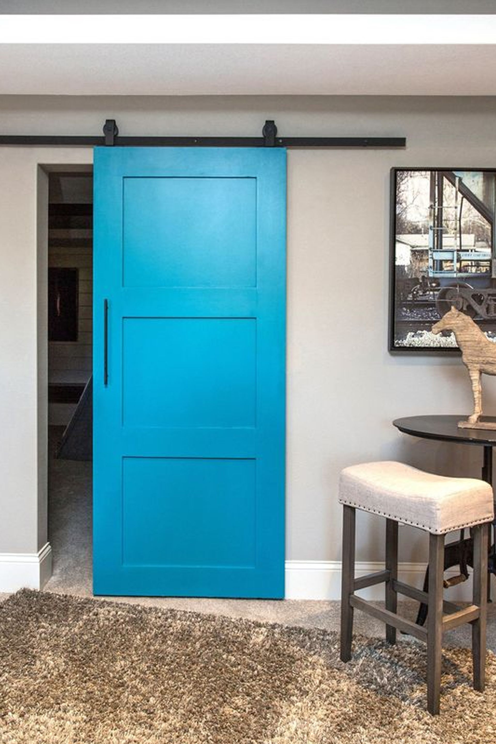 Closed white sliding closet doors in a room with wood-look flooring and pale yellow walls.