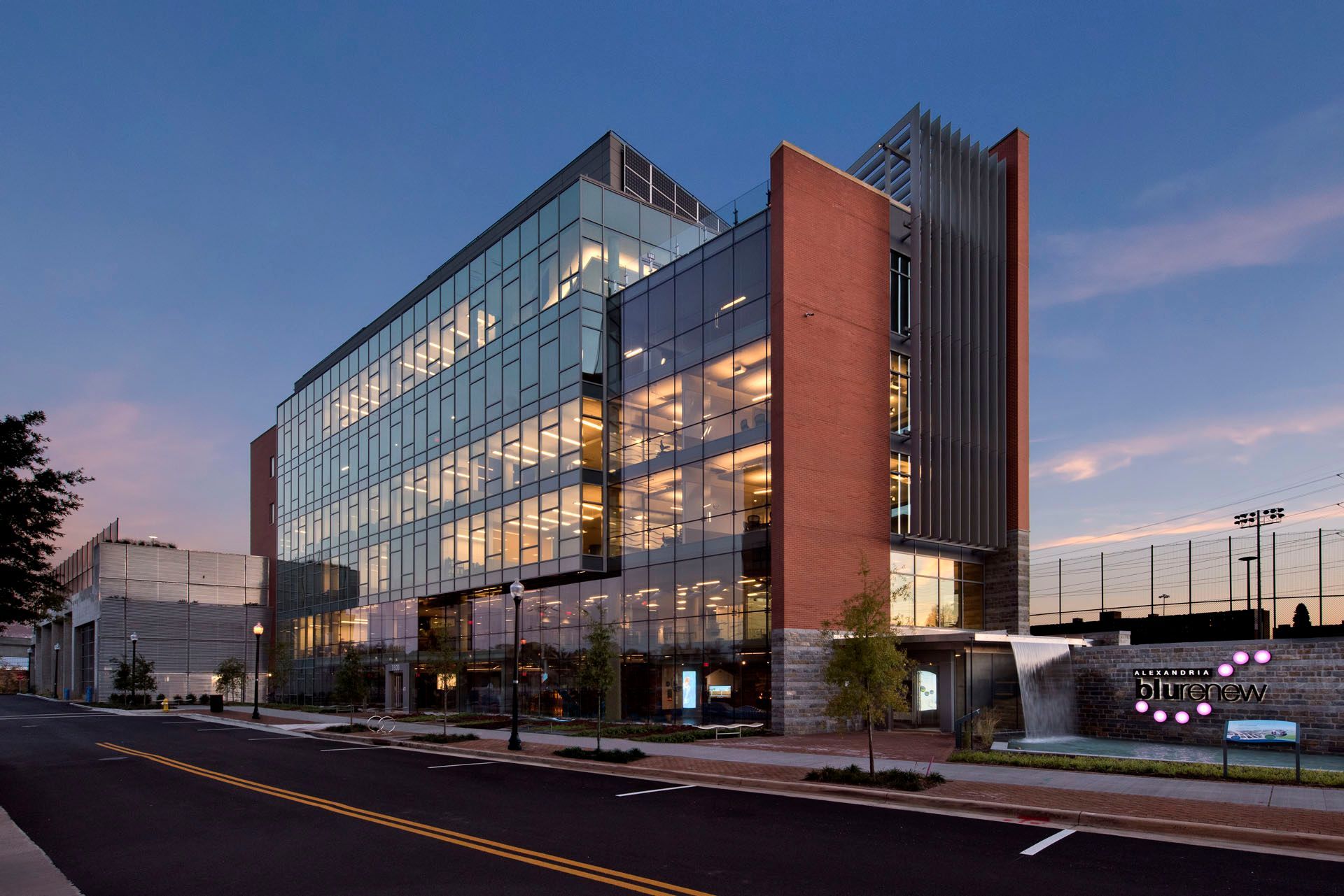 A large building with a lot of windows is lit up at night.