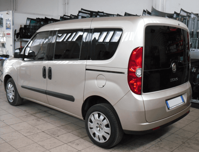 Furgone Fiat Doblò beige parcheggiato all'interno di un edificio con vetri oscurati.