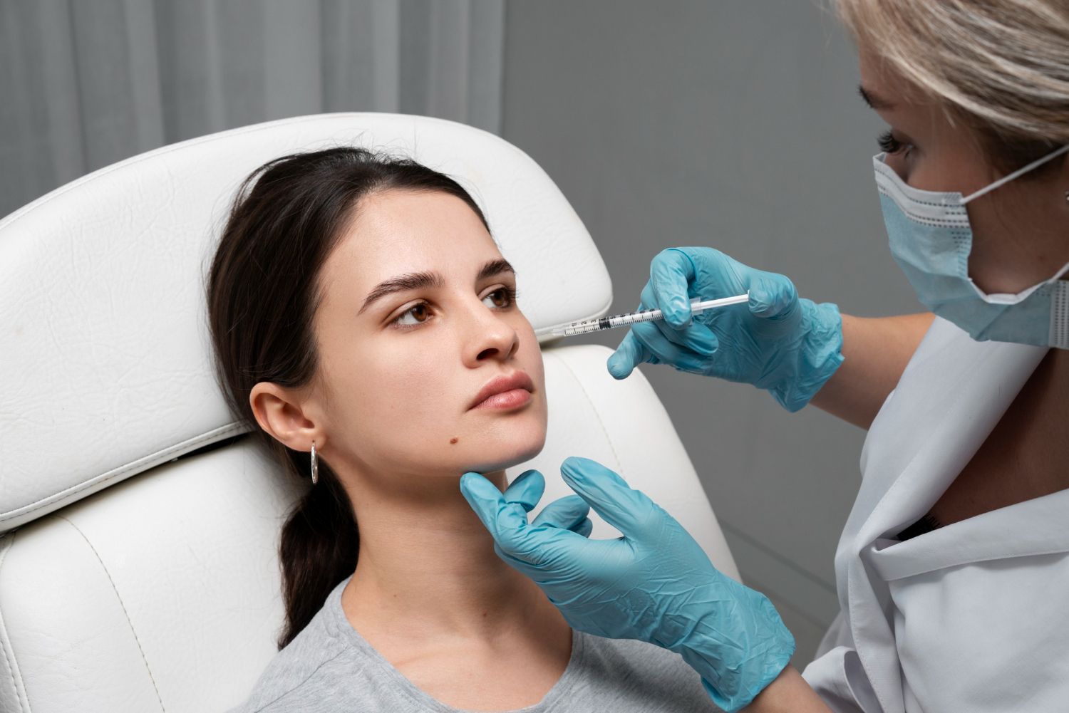 A woman is getting a botox injection in her face.