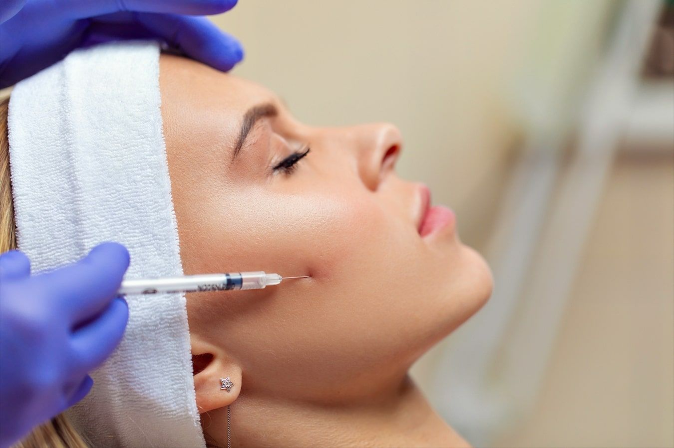 A woman is getting a botox injection in her face.