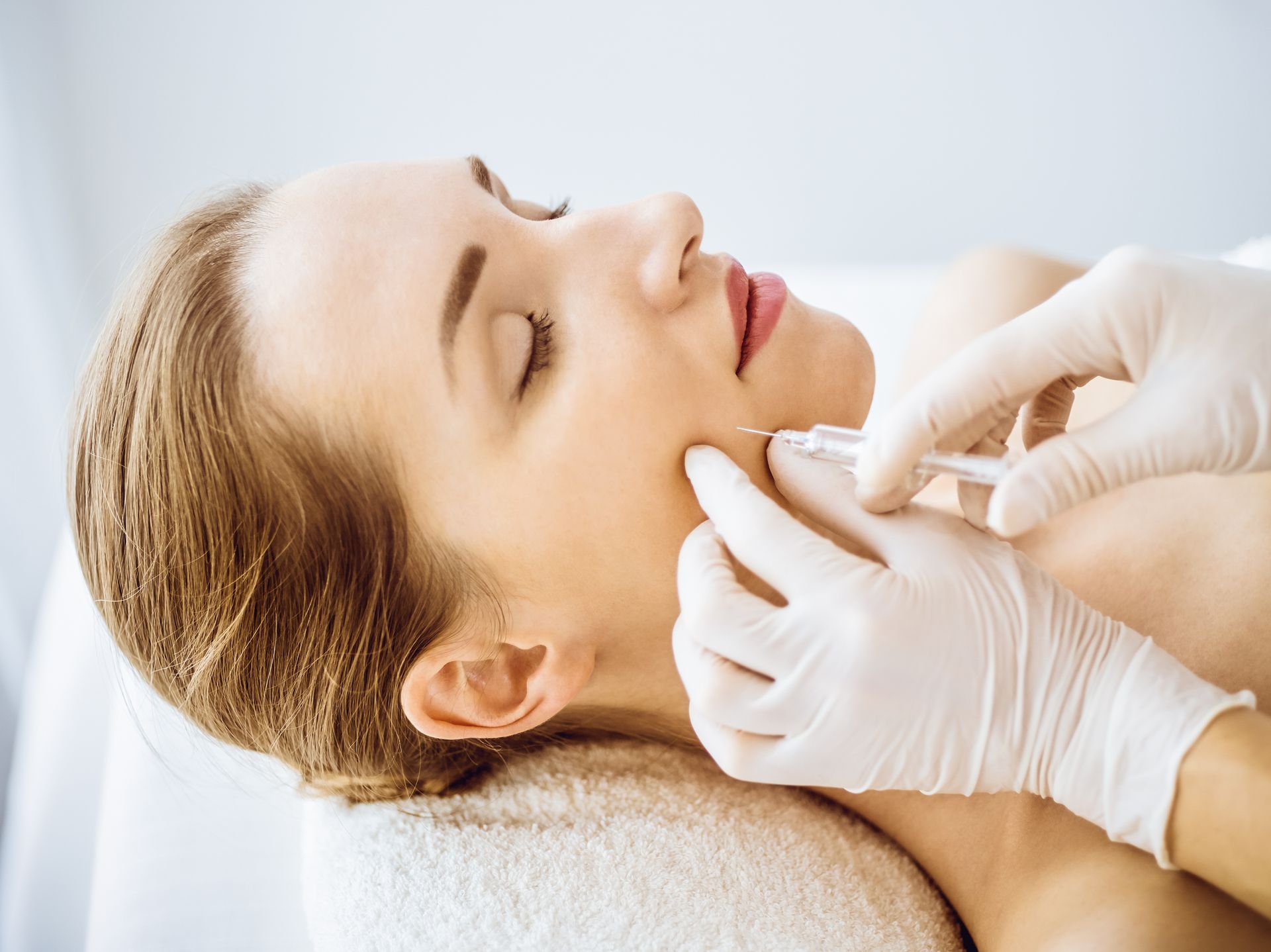 A woman is getting a botox injection in her face.