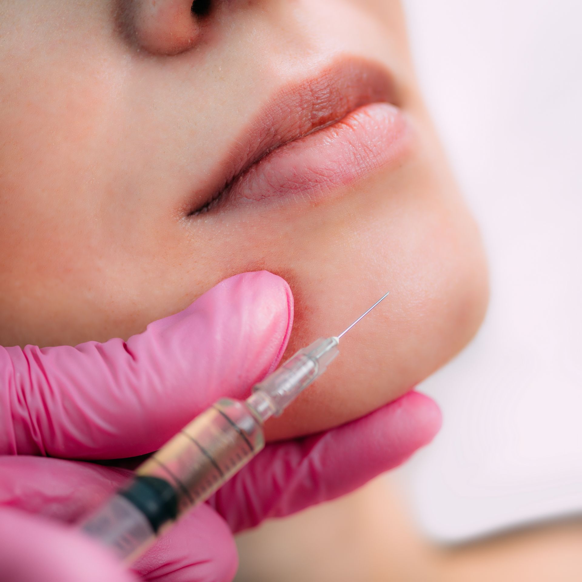 A woman is getting a botox injection in her face.