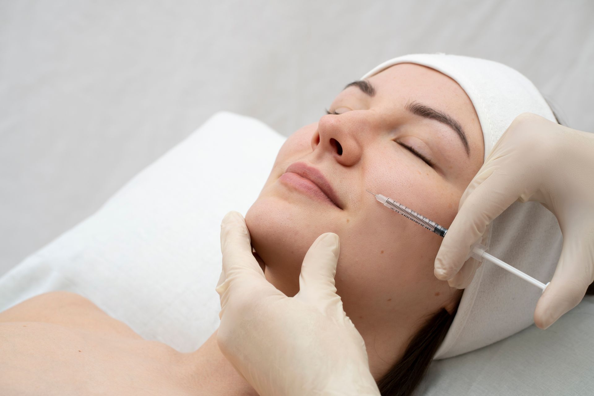 A woman is getting a botox injection in her face.