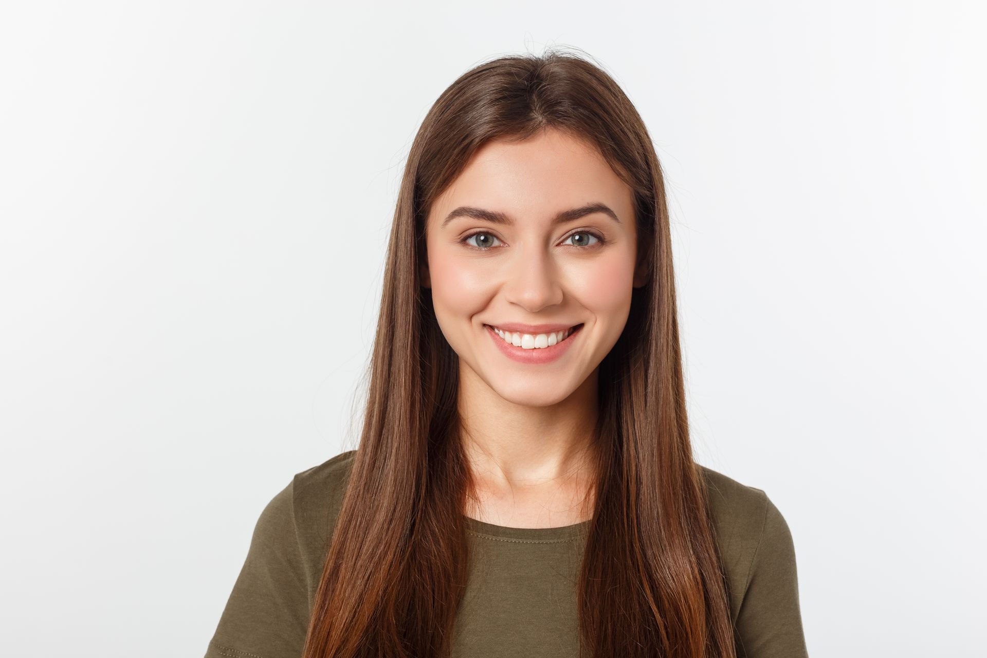 A woman with long hair is smiling and looking at the camera.