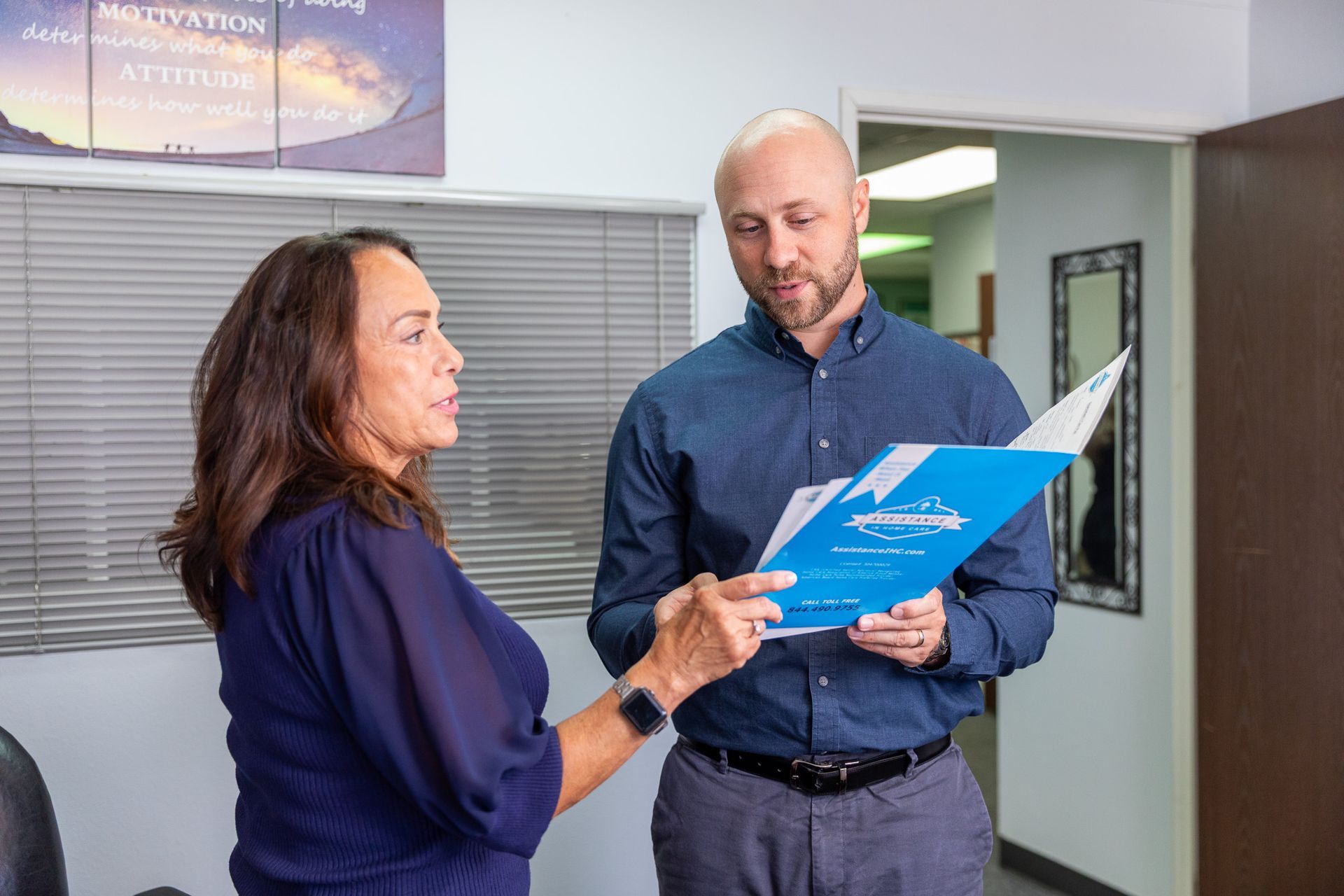 Two people reviewing a document in an office setting.